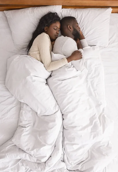 Afro pareja abrazándose mientras duermen juntos en la cama, vista superior —  Fotos de Stock