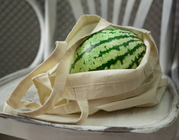 Creative watermelon in eco friendly shopping bag on chair — Stock Photo, Image