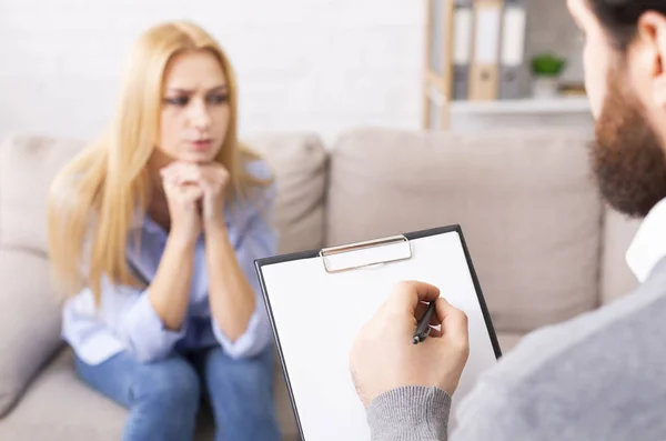 Depressieve vrouw in gesprek met psycholoog, specialist die aantekeningen maakt — Stockfoto