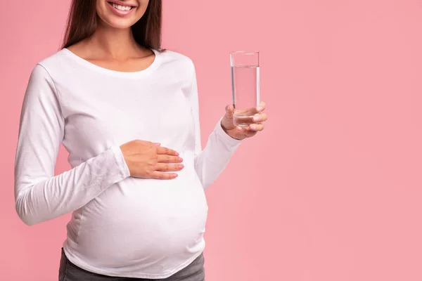 无法辨认的孕妇手里拿着一杯水，站着，工作室，收割 — 图库照片