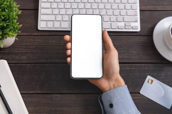 Funcionário de escritório irreconhecível demonstrando smartphone com tela em branco no local de trabalho — Fotografia de Stock