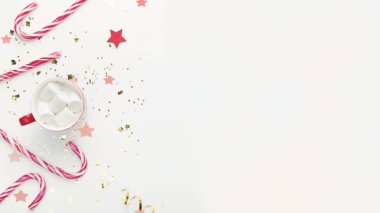 Şeker kamışı ve bir fincan sıcak kakao. Beyaz üzerine lokum.