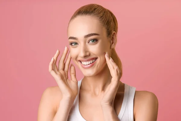 Kobieta ze zdrową skórą dotyka twarzy i uśmiecha się — Zdjęcie stockowe