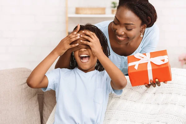Szczęśliwy czarny matka zaskakując jej córka z prezent — Zdjęcie stockowe