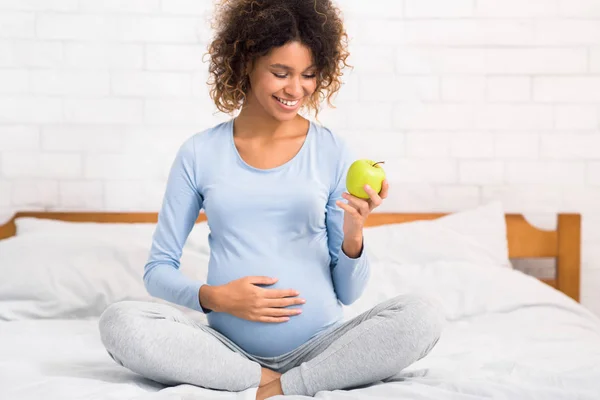 Nutrição orgânica. Mulher grávida excitada comer maçã — Fotografia de Stock