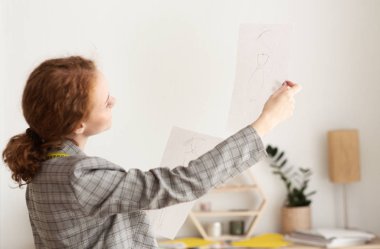 Dikkatimi veriyorum. Tasarımcı yeni çizimlere bakıyor