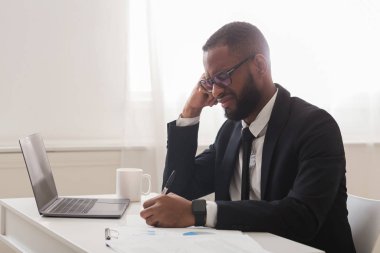 Ofisteki belgelerle uğraşan yorgun girişimci