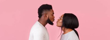 Öpüşmek üzere olan siyahi erkek ve kadının romantik fotoğrafı.