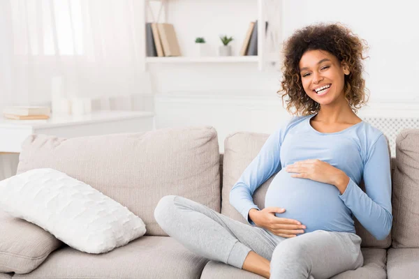 Прекрасна вагітна жінка обіймає живіт вдома — стокове фото