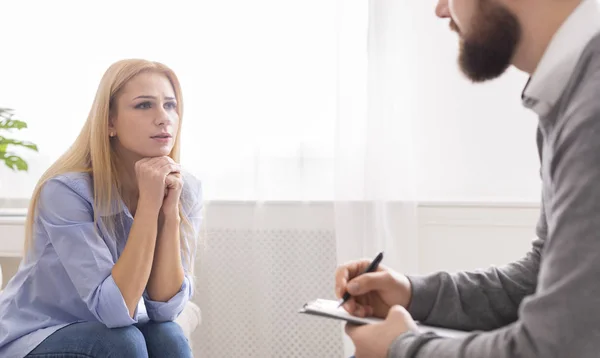 Mulher triste conversando com terapeuta masculino durante sessão pessoal — Fotografia de Stock