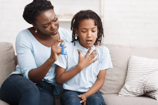 为女儿拿哮喘吸入器的黑人母亲 — 图库照片