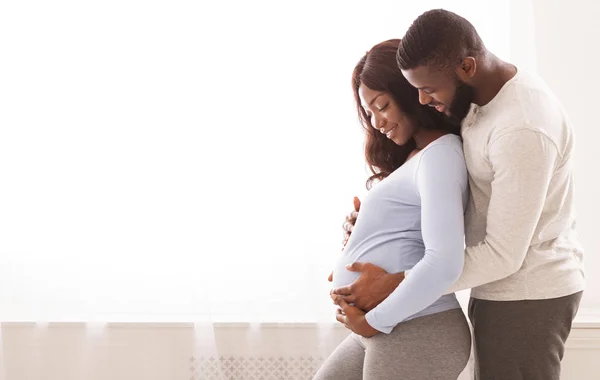 怀孕妇女和丈夫抱在窗边 — 图库照片