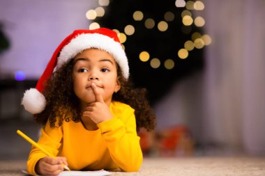 Düşünceli Afrikalı kız Noel Baba 'dan ne isteyeceğini düşünüyor.