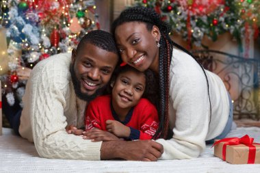 Mutlu Afro-Amerikan ailesinin Noel arifesindeki portresi