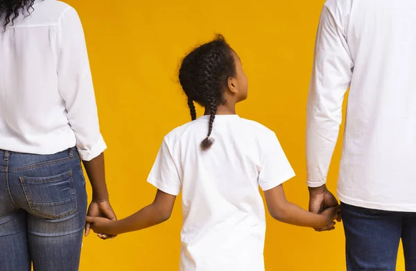 Bakifrån av afrikansk mor, far och dotter håller hand tillsammans — Stockfoto