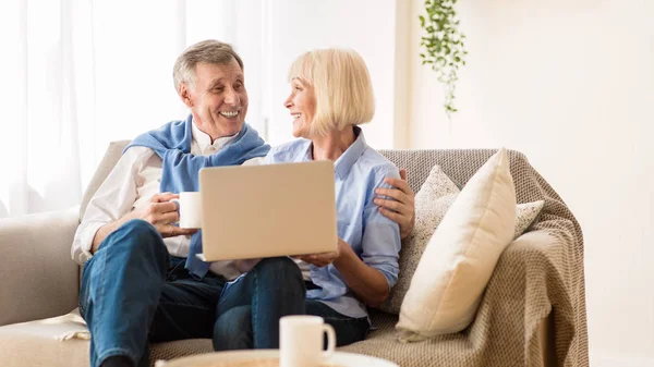 Gammal par köpa online på laptop och dricka kaffe — Stockfoto