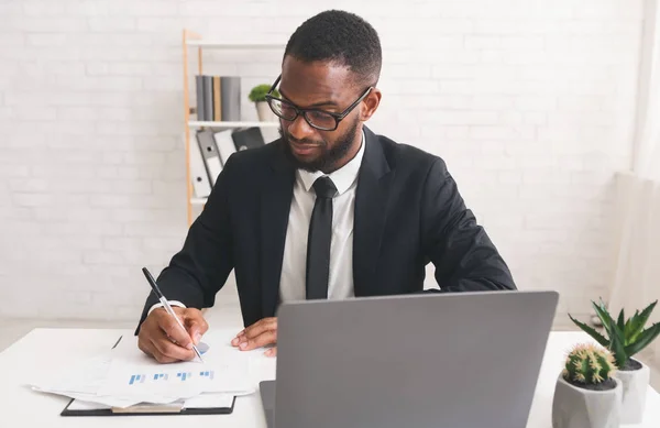 Serious young manager working with documents in his office