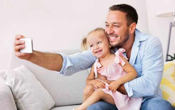 Sorrindo pai e menina tomando selfie — Fotografia de Stock