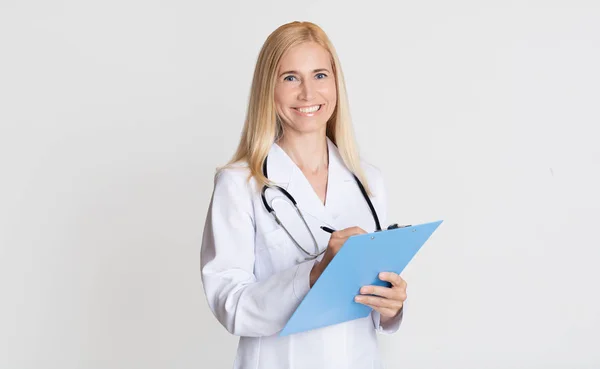 Medical report. Middle-aged woman holding folder, grey background — Stock Photo, Image
