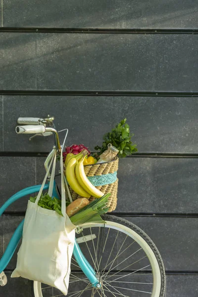 Bicicletta ecologica blu con frutta e verdura oltre muro di cemento — Foto Stock