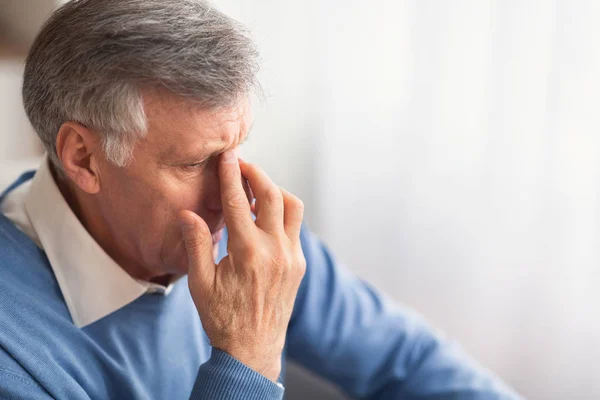 Verzweifelter älterer Mann, der zu Hause auf der Couch sitzt — Stockfoto