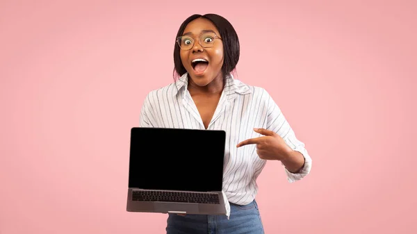 Mädchen zeigt Laptop leeren Bildschirm Zeigefinger, Studioaufnahme, Panorama — Stockfoto