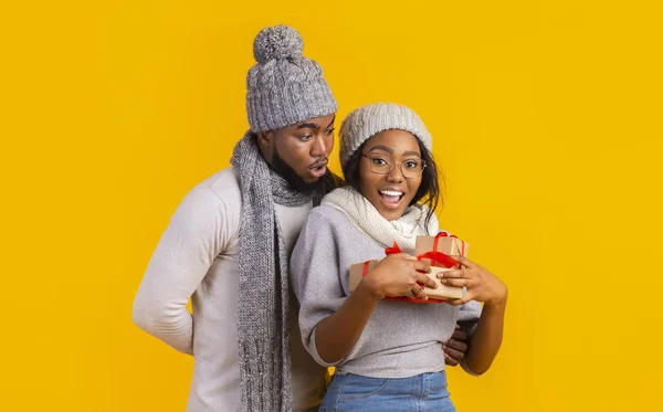 Feliz menina afro inverno segurando presentes de Natal, namorado ficar para trás — Fotografia de Stock