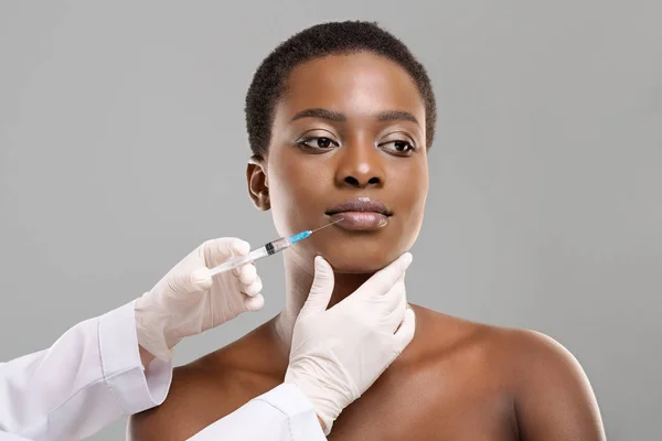 Mujer afroamericana haciendo procedimiento de aumento de labios por médico —  Fotos de Stock