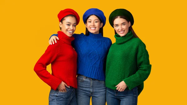 Tres diversas niñas abrazando de pie sobre fondo amarillo, Panorama — Foto de Stock