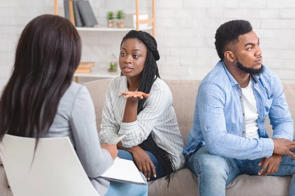 Vrouw zitten naast haar ontevreden echtgenoot en praten met counselor — Stockfoto