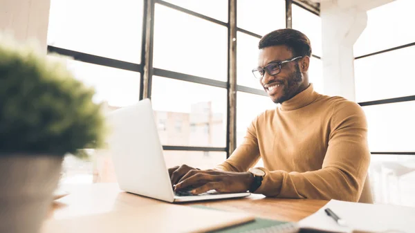 Tevreden Afrikaans-Amerikaanse manager typen op toetsenbord — Stockfoto