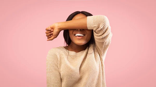 Smiling girl covering eyes with hand standing, pink background, panorama — Stock Photo, Image