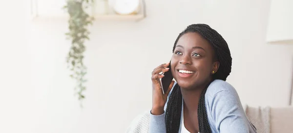 Веселая африканская американка разговаривает по мобильному телефону дома — стоковое фото