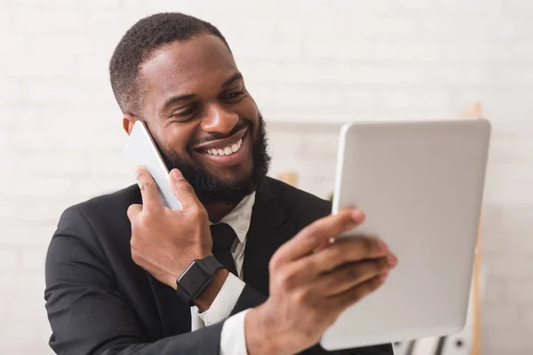 Biznesmen korzystający z tabletu cyfrowego i rozmawiający przez telefon — Zdjęcie stockowe