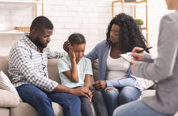 Des parents noirs bienveillants apaisant leur petite fille lors d'une consultation psychologue — Photo