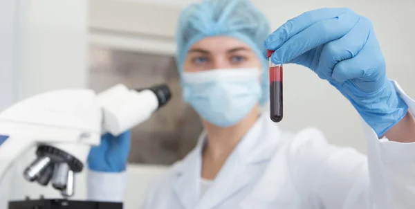 Close up of blood in test tube in woman hand, blurred motion — Stock Photo, Image