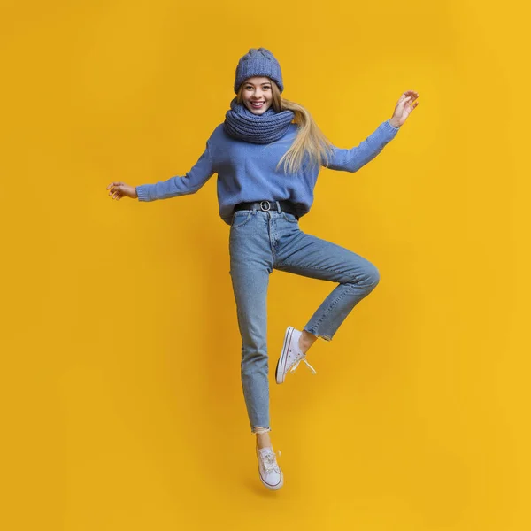 Young beautiful girl in warm clothes jumping up — Stock Photo, Image