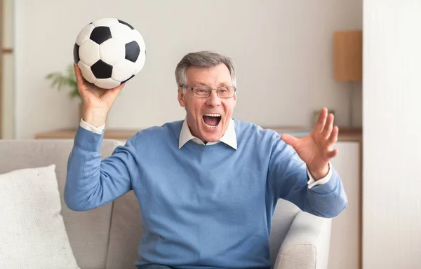 Idősek focit néznek a tévében, a kanapén ülnek a házban. — Stock Fotó