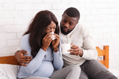 Yakışıklı adam hasta hamile kadınıyla ilgileniyor.