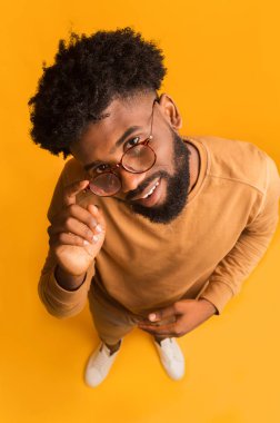 Gözlüklü heyecanlı genç adam kameraya bakıyor.