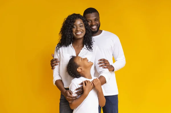 Amar a la familia negra con hija abrazando y sonriendo a la cámara —  Fotos de Stock