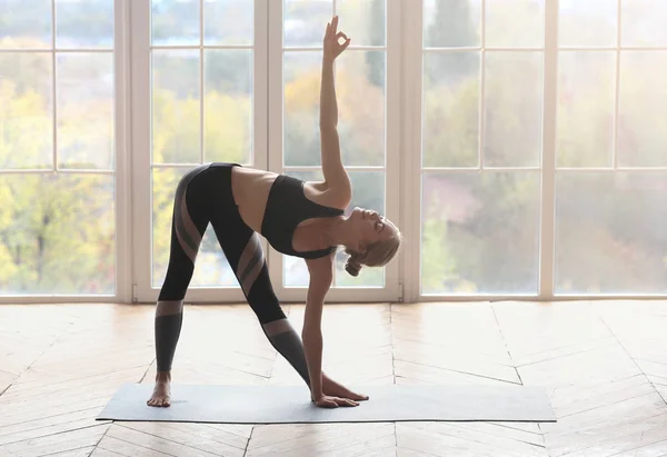 Flexibilní dívka tvorby trojúhelníku jóga póza ve fitness studiu — Stock fotografie