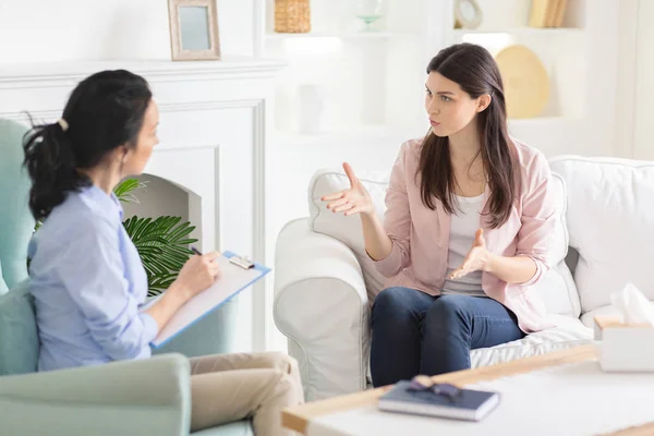 Emotional woman explaining her feelings to psychotherapist