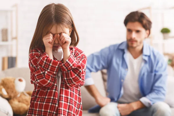 Ragazzina che piange dopo aver litigato con papà, padre arrabbiato dietro — Foto Stock