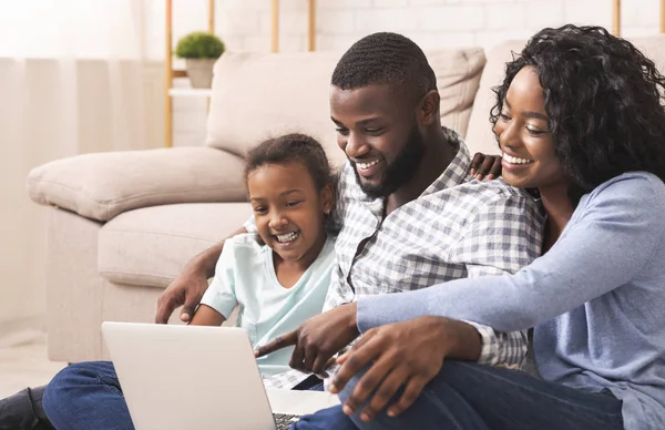 Glädjande afrikansk amerikansk familj använder laptop hemma tillsammans — Stockfoto