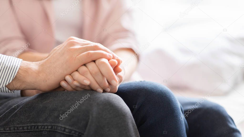 Married couple holding each other hands, giving psychological support