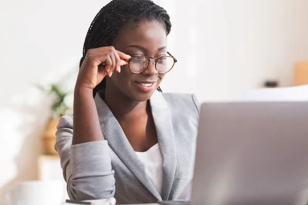 Afro secretary wearing glasses and working with papers and laptop — Stock Photo, Image
