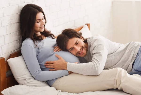 Liefhebbende man luisteren buik van zijn zwangere vrouw — Stockfoto