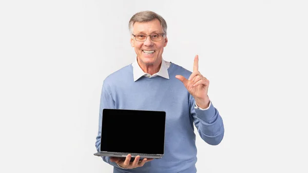 Senior Mann zeigt Laptop leeren Bildschirm stehend, weißer Hintergrund, Panorama — Stockfoto