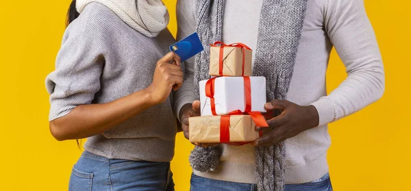 Mężczyzna ręce niosące prezenty, kobieta ręka z kartą kredytową — Zdjęcie stockowe